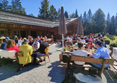 Gäste sitzen bei der Mittagsrast auf der Alm